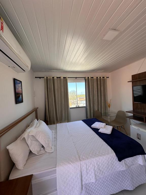 a bedroom with a large white bed in a room at Pousada Marihá in Piranhas