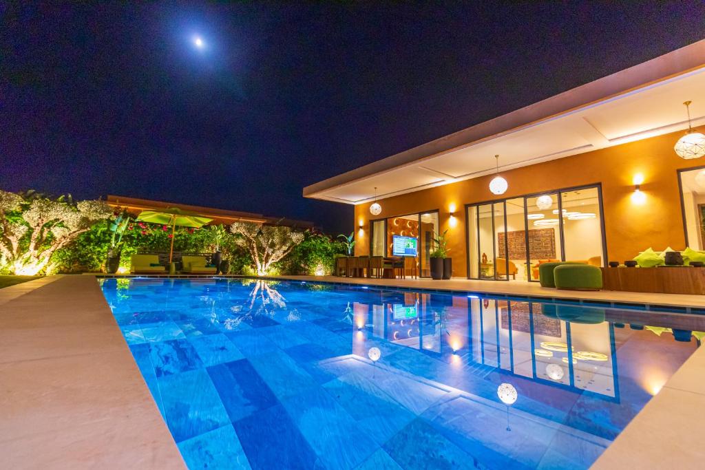 a swimming pool in a house at night at Villa Jamila Marrakech in Segraga