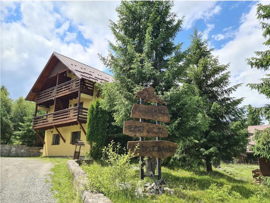 a directional sign in front of a house at Zori de Zi & Apus de Soare in Bălceşti