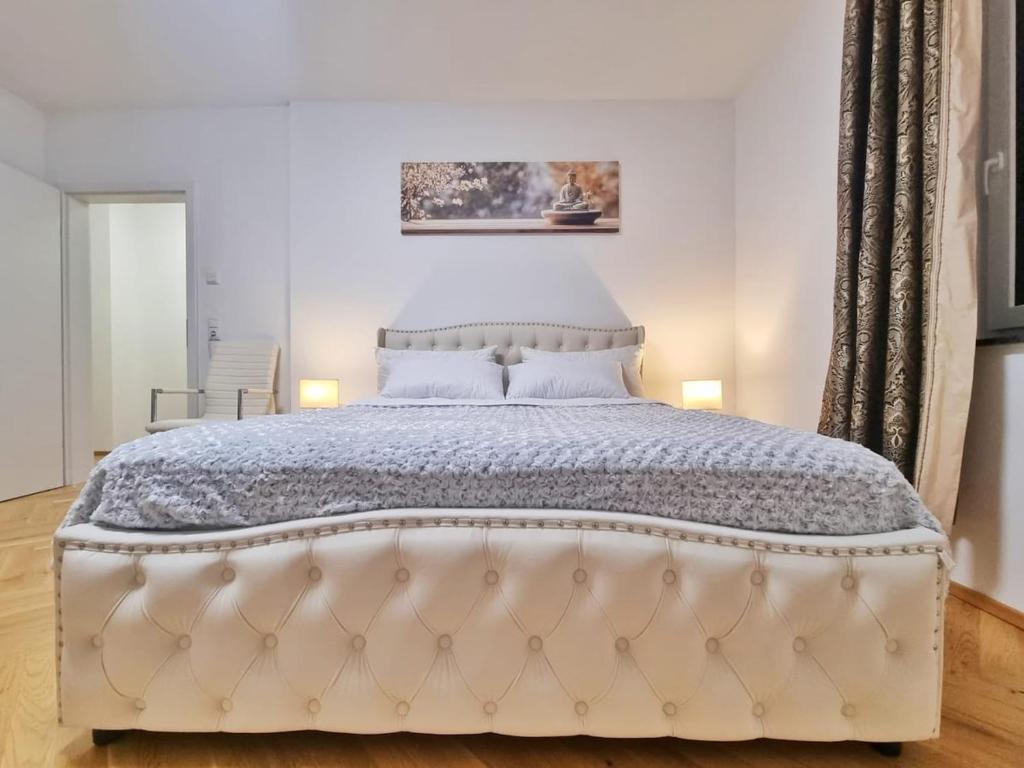 a bedroom with a large white bed with two lamps at Ravensburg City Apartment in Ravensburg