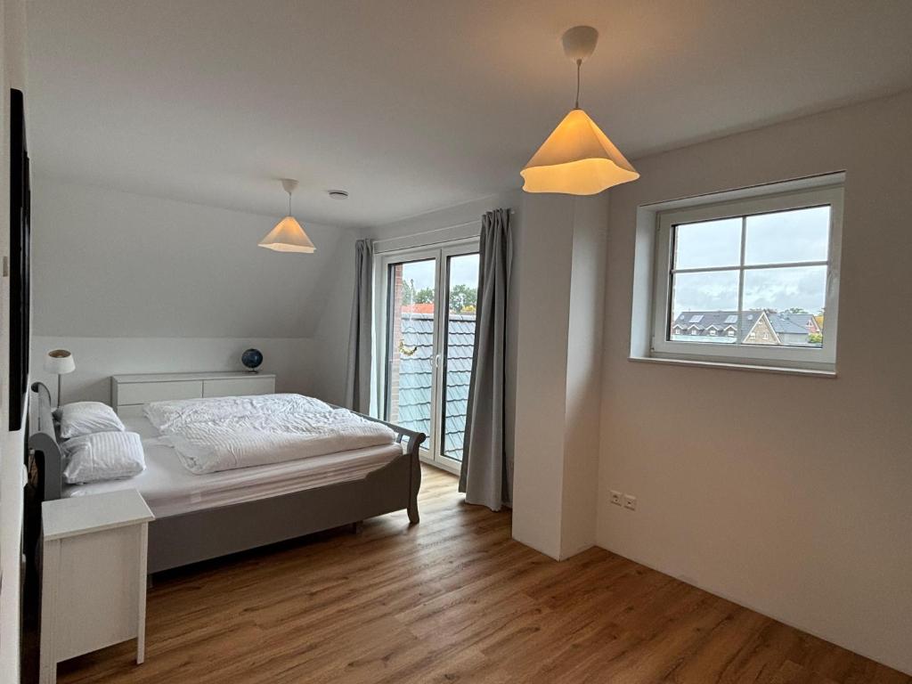 a bedroom with a bed and a window at Premium Landhauswohnung in Neuenkirchen