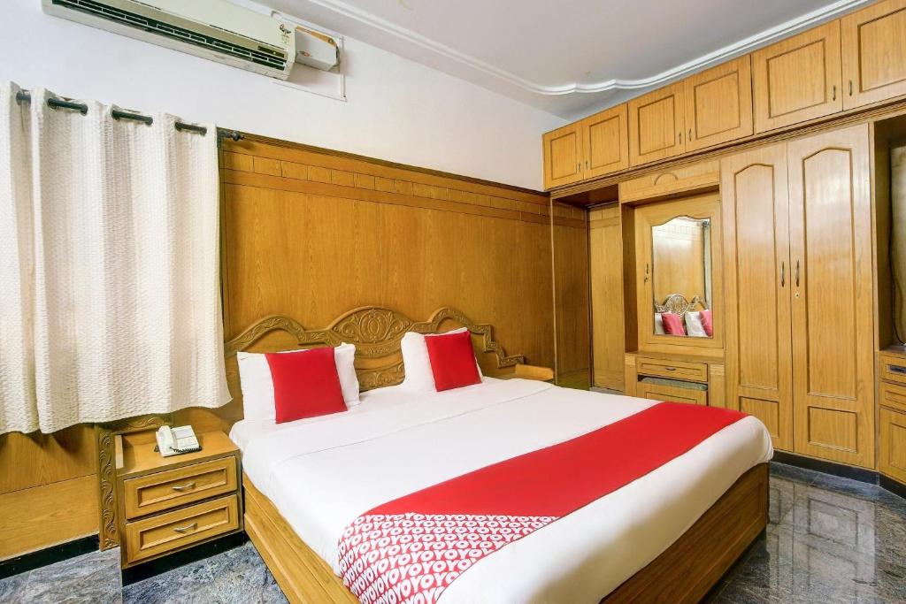 um quarto com uma cama grande com travesseiros vermelhos em Hotel O Vivekam Home Stay em Coimbatore