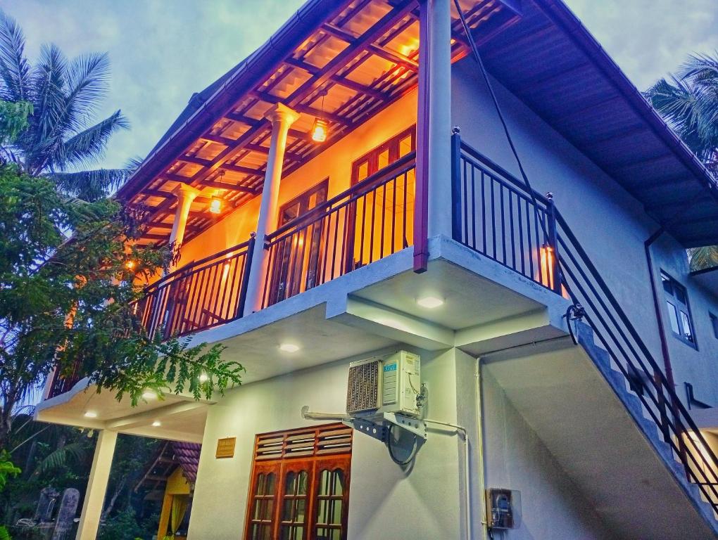 een huis met een balkon erbovenop bij SandaLuck House Ahangama in Ahangama