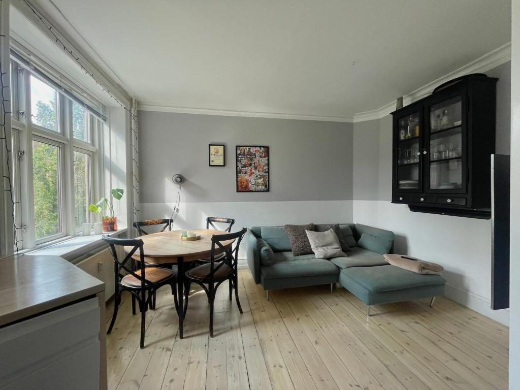 a living room with a table and a couch at Apartment in heart of Amager in Copenhagen