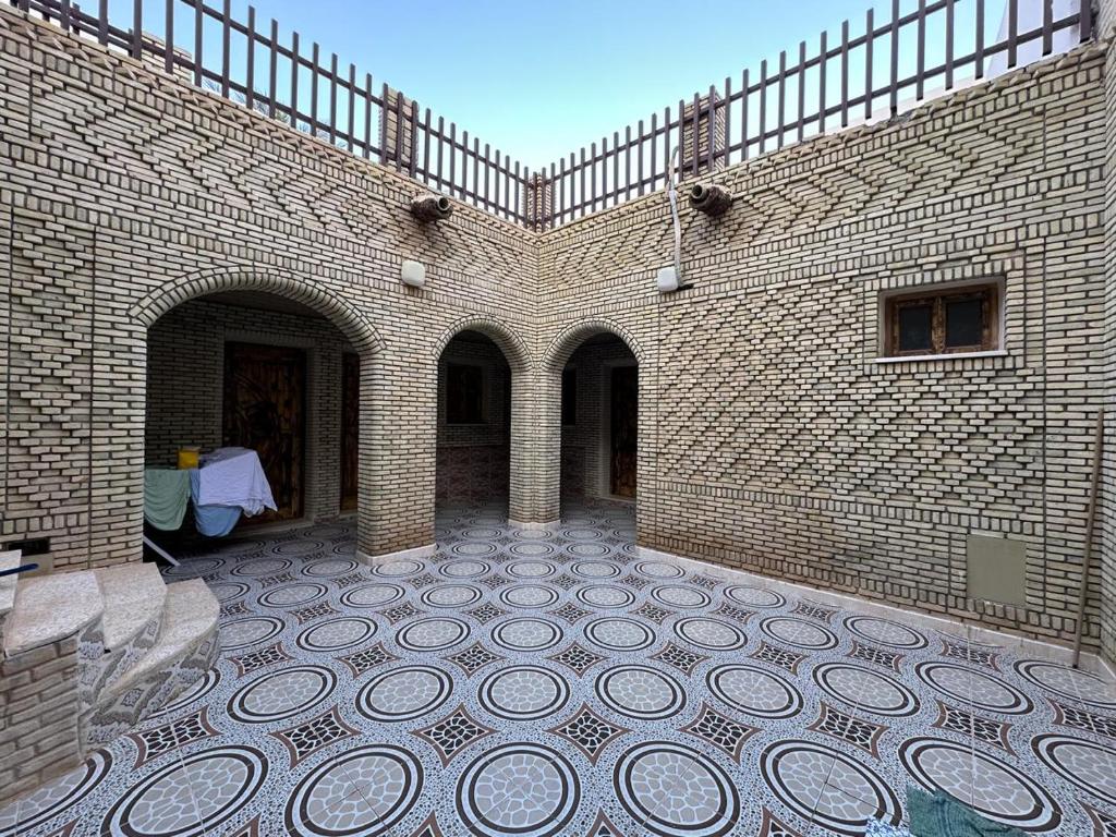 a large brick building with a tiled courtyard with a table at Dar Ben Othman in Tozeur