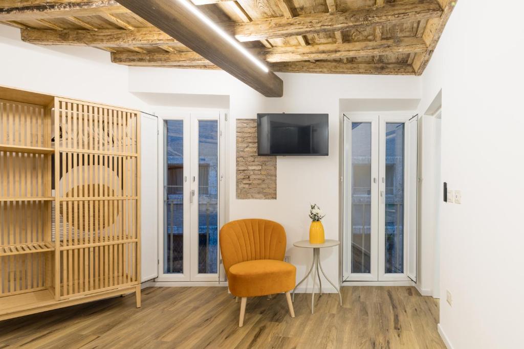 a room with a chair and a tv and windows at Boutique Atrium Pantheon in Rome