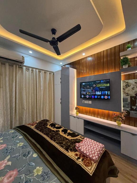 a bedroom with a flat screen tv on the wall at Premium studios in Greater Noida