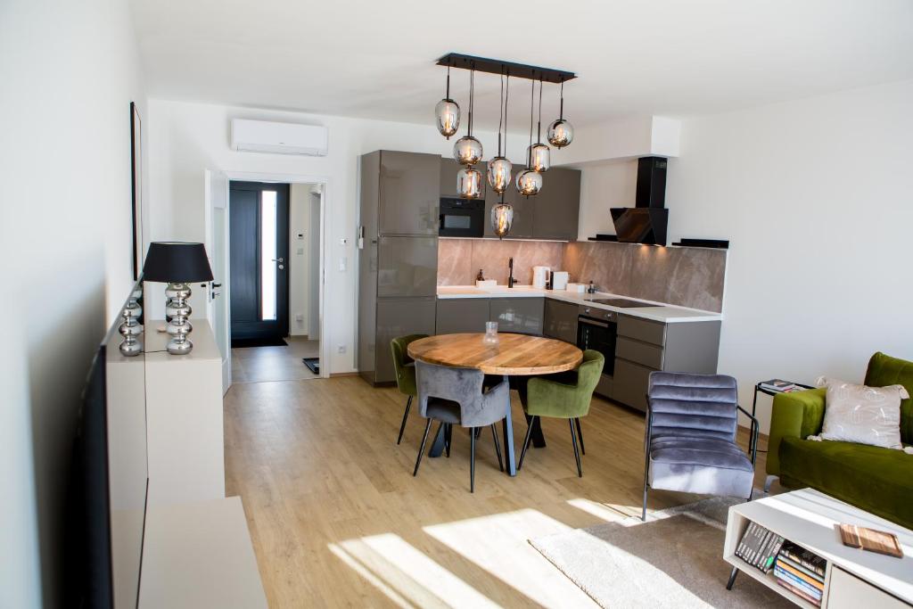 a kitchen and living room with a wooden table in a room at Vista Pálava - Apartmán Pasohlávky in Pasohlávky