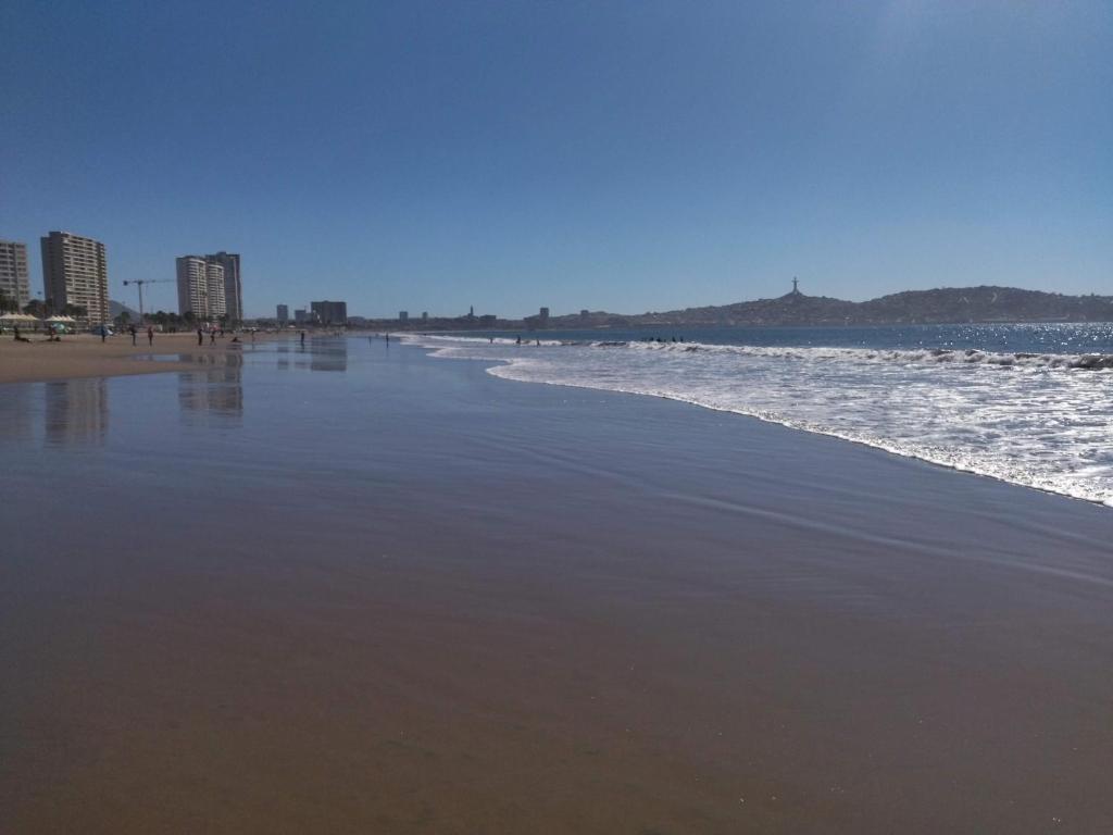 a beach with the ocean and buildings in the background at Departameto comodo Coquimbo HA in El Cerrillo