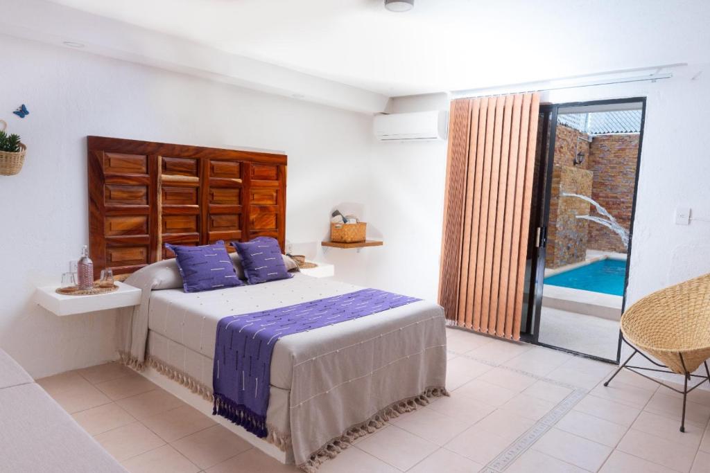 a bedroom with a bed with blue pillows at Casa Rincón Bonito in Puerto Escondido