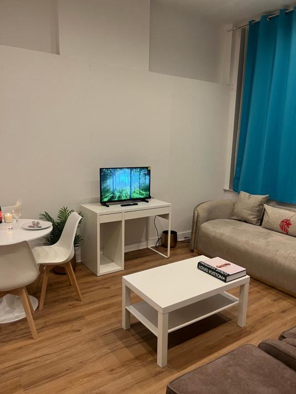 a living room with a couch and a tv at The central stay in Mellet