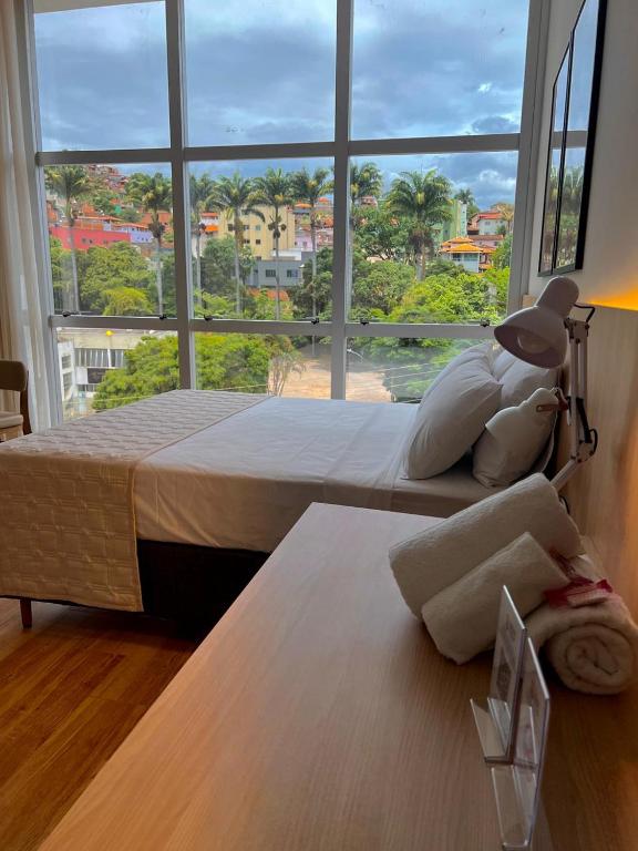 GuanhãesにあるGran Vale Hotelのベッドが2つと大きな窓がある寝室