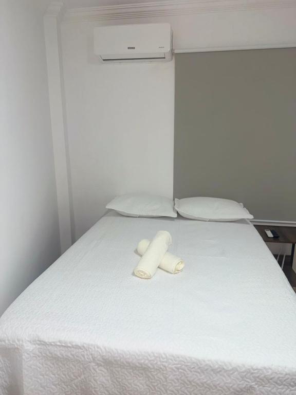 a bed with two white towels on top of it at Studio apartment - Bom Retiro - S05 in Ipatinga