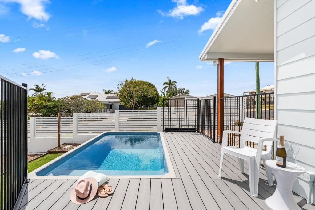 a house with a swimming pool on a deck at 'Short Break' - Luxurious Coastal Retreat with Pool and BBQ in Urangan