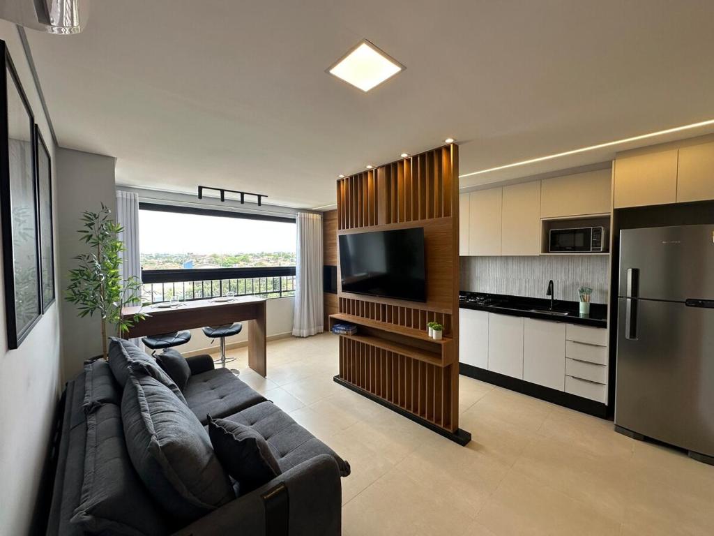 ein Wohnzimmer mit Couch und Küche in der Unterkunft Apto Moderno com 2 quartos em Londrina in Londrina