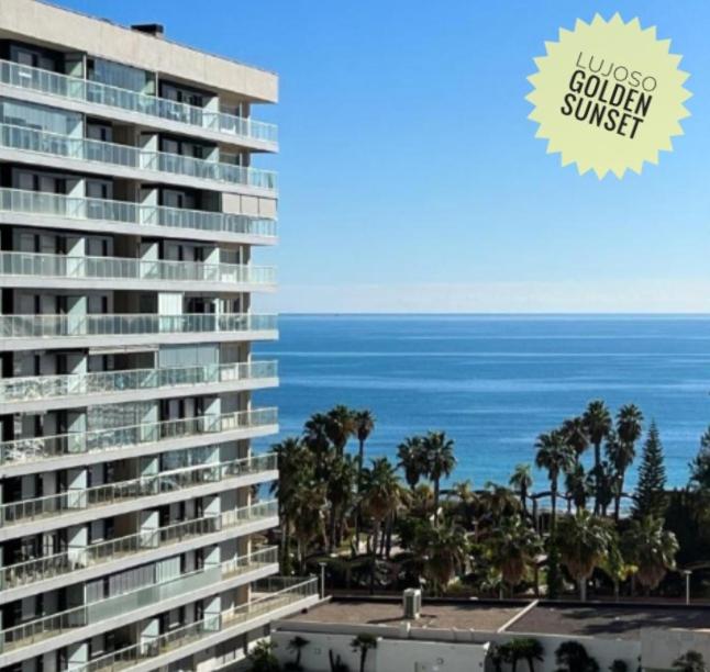 a large apartment building with the ocean in the background at Lujoso Golden Sunset in Oropesa del Mar