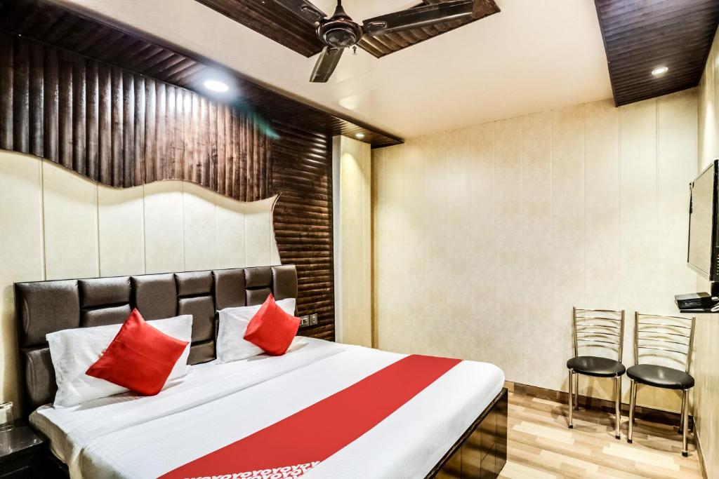 a bedroom with a bed with red pillows at Hotel O JPS Galaxy Hotel in New Delhi