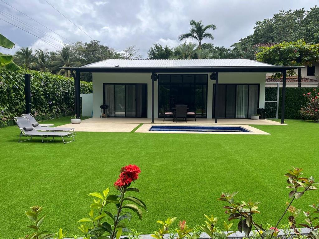 a house with a large yard with a green lawn at Casa Flor in Playa Avellana