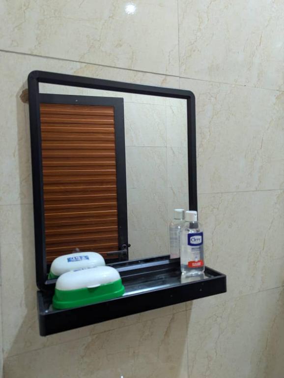 a mirror on a shelf in a bathroom at Ocean Breeze Apartments in Dar es Salaam
