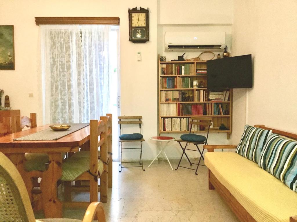 ルートラキにあるLucy's comfy apt in town centre by the seaのソファとテーブルとテレビのあるリビングルーム