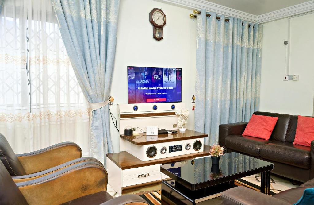 Una sala de estar con un sofá y un televisor. en Two Bedrooms Standby Generator DSTV Netflix W-iFi, en Takoradi