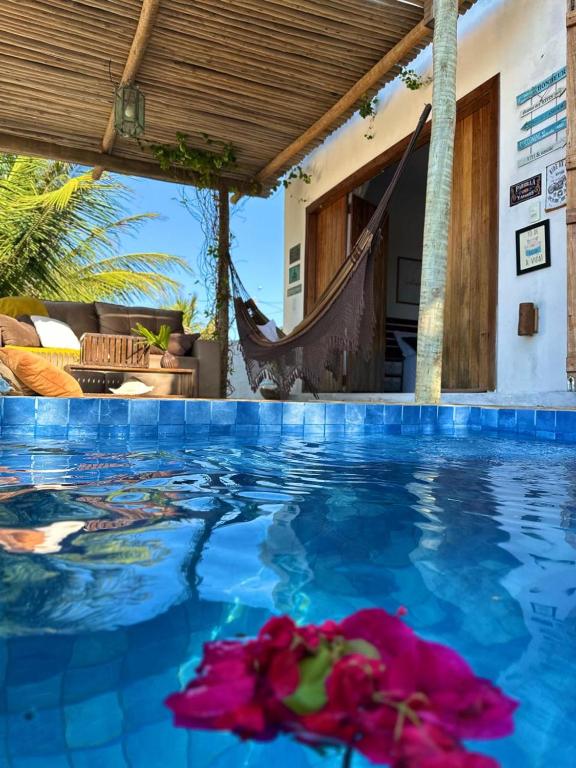 a pool with a hammock in a resort at Bangalô Exclusivo Pontal do Maceió in Fortim