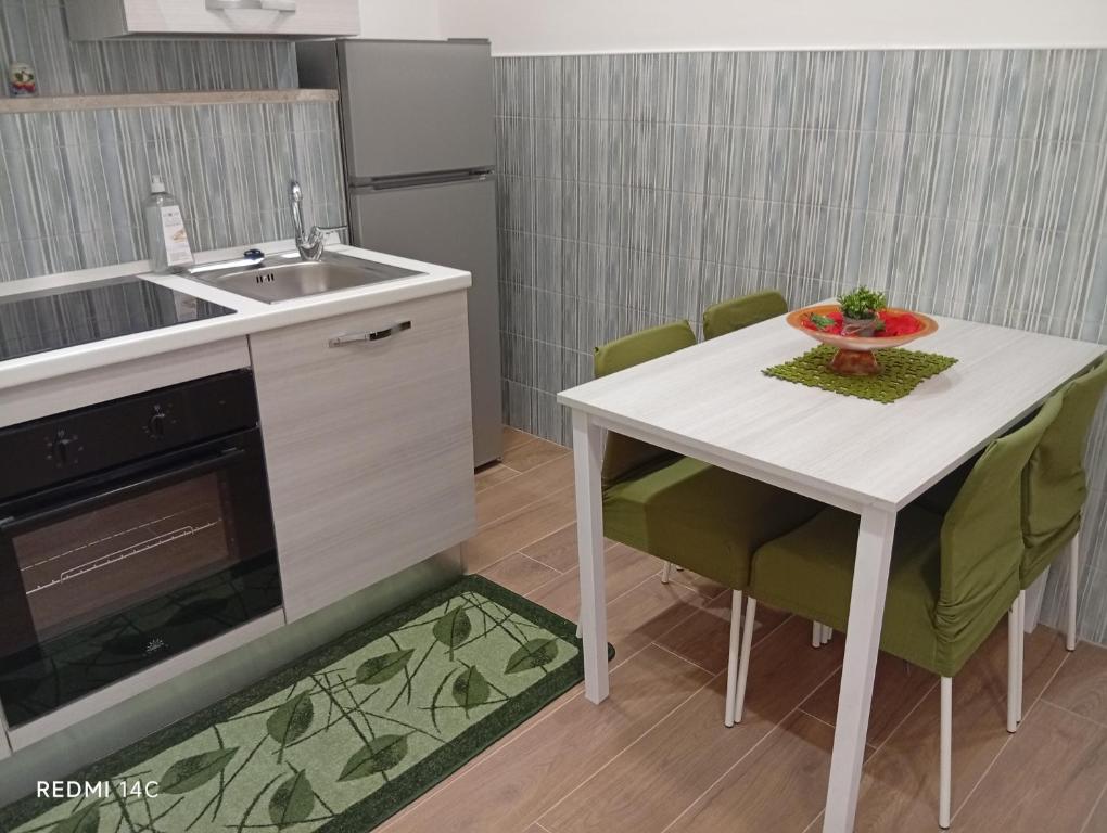 a kitchen with a white table and chairs and a sink at villa del mare in Nettuno