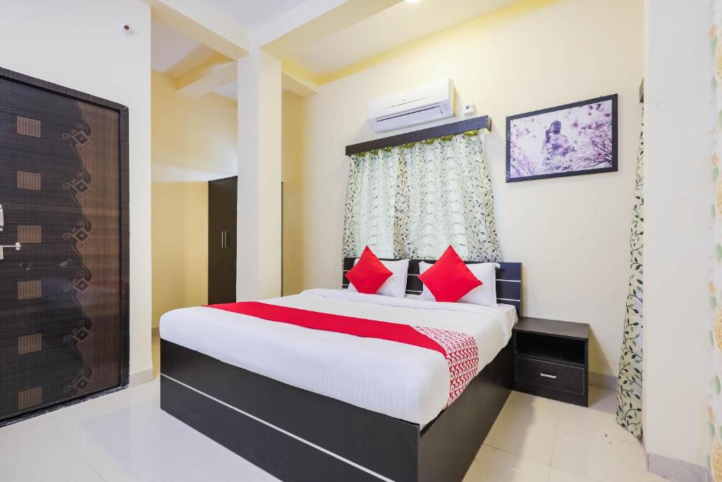 Un dormitorio con una cama grande con almohadas rojas. en Hotel O The Dreams, en Indore