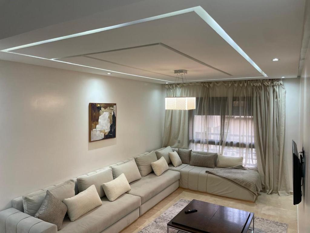 a living room with a couch and a large window at Appartement Le Guéliz,au centre de Marrakech, pool & fast WiFi in Marrakech