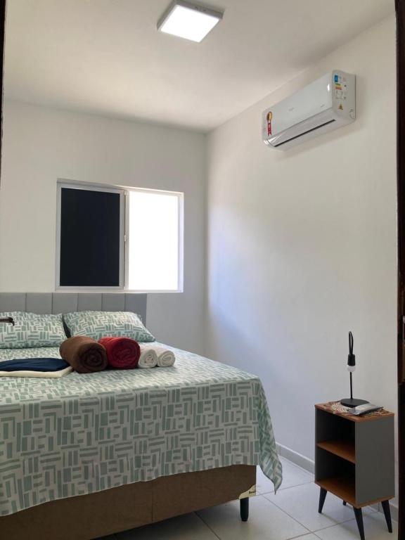 a bedroom with a bed with a tv on the wall at Descanse perto do aeroporto e Conheça Maceió - 24h in Maceió