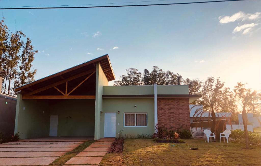 a small house with two chairs in front of it at Refugio 4 suites com ar condicionado e piscina in Santa Bárbara do Rio Pardo