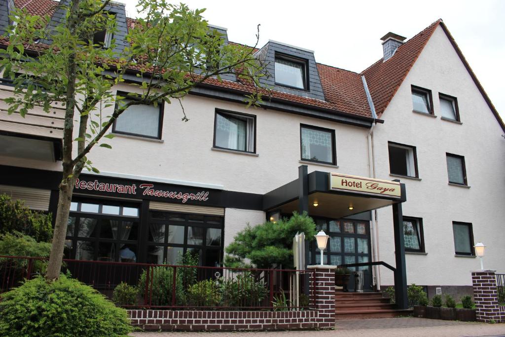 een wit gebouw met een bord ervoor bij Hotel Gaya in Bad Soden am Taunus