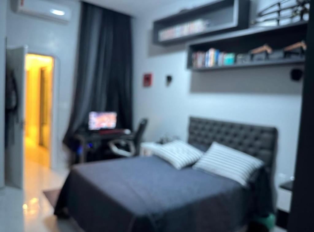 a bedroom with a bed and a desk with a laptop at Lar dos Fernandes in Belém