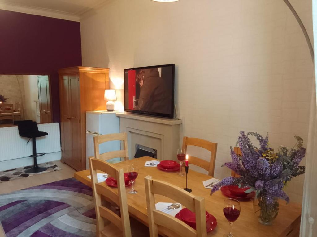 a dining room with a table with a fireplace and a television at Executive Suite at Ideal home & cottage, Inviting 2 Bedroom apartment, Sleep 6 Ideal for contractors, family & Groups in Birmingham