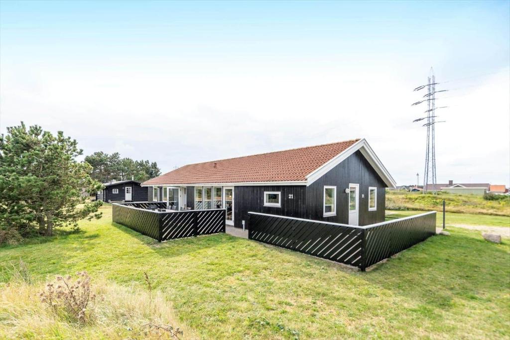 a black house with a brown roof at 340-Hvide-Sande-Fyrmarken-21 in Hvide Sande
