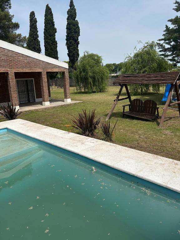 a swimming pool with a swing and a playground at Quinta El Oasis Junin in Junín