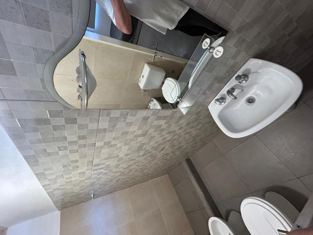 a bathroom with a sink and a mirror and a toilet at Quinta El Oasis Junin in Junín