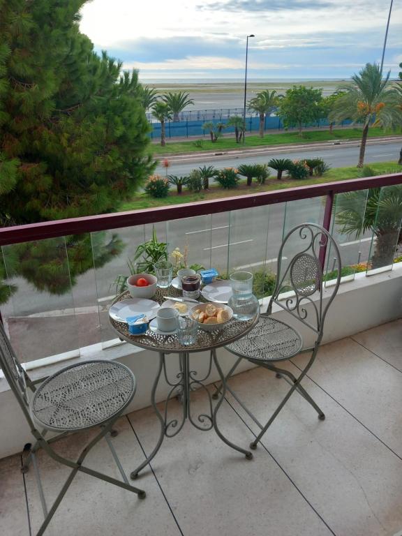 a table and chairs on a balcony with a view of the ocean at 2 Bedroom Ocean view Apartment in Nice