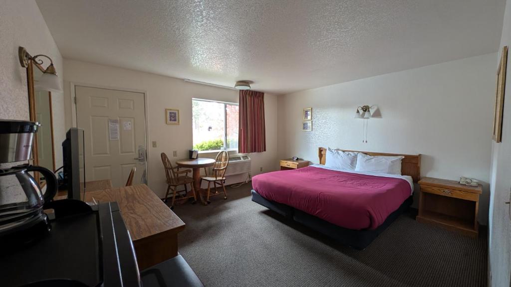 a hotel room with a bed and a table at Himont Motel in Fall River Mills