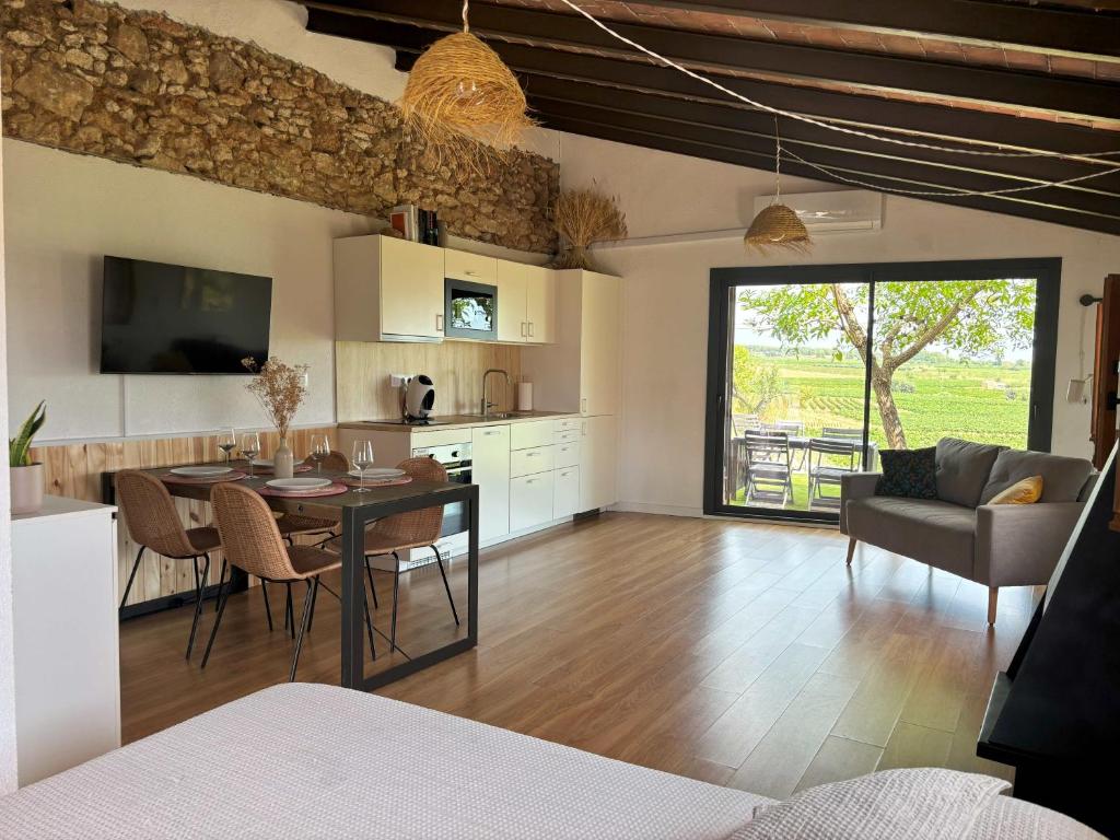 a kitchen and living room with a table and chairs at Cabernet Rural in Sant Jaume dels Domenys