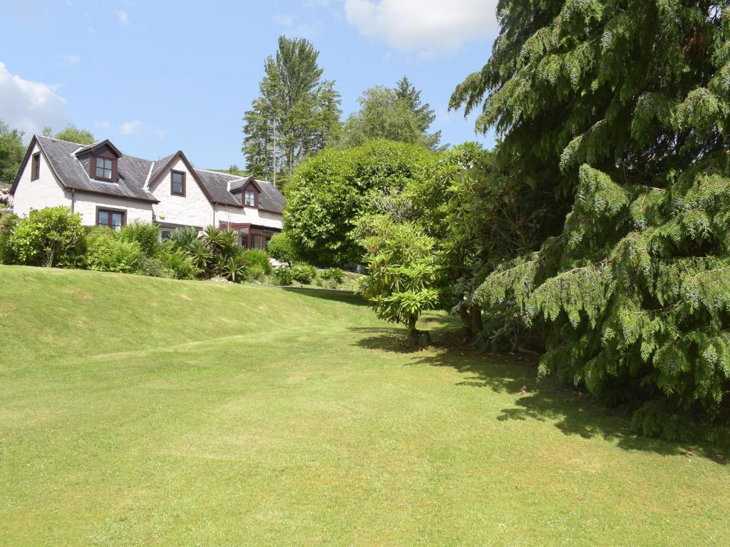 a house on a hill with a green yard at Cluniter Cottage in Innellan