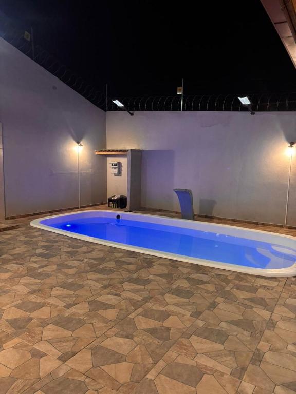 a large blue swimming pool in a room at Cantinho Aconchegante in Macapá
