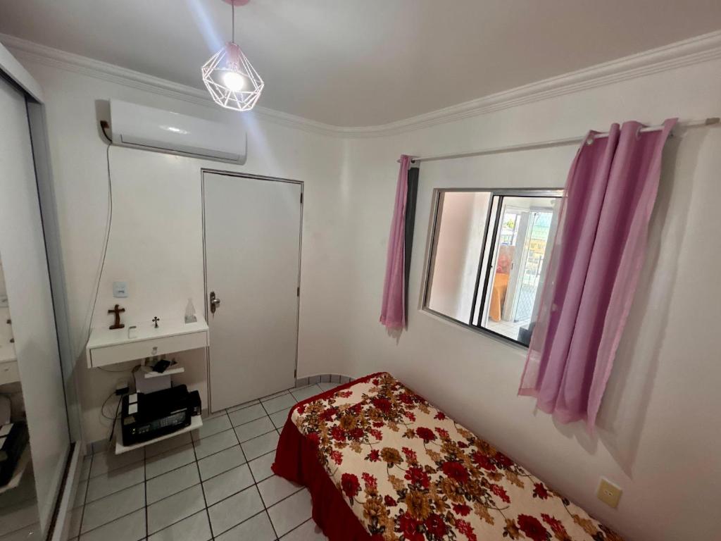a small bedroom with a bed and a window at Casa de praia inteira pé na areia Maragogi in Maragogi