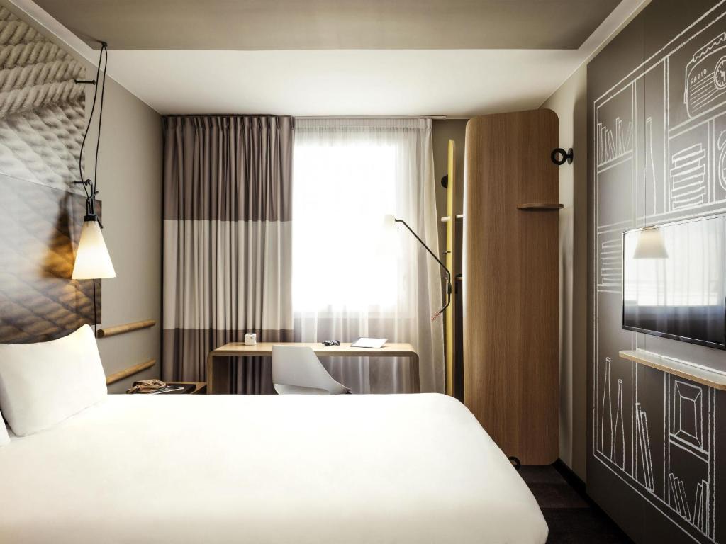une chambre d'hôtel avec un lit et un bureau dans l'établissement ibis Orleans Centre Gare, à Orléans