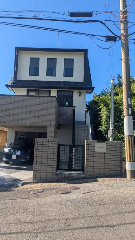 a house with a gate in front of it at HARE 天然温泉かけ流し ビーチ車5分 三段壁近くの閑静な高台 BBQ利用は別料金頂きます GuestHouse HARE in Shirahama