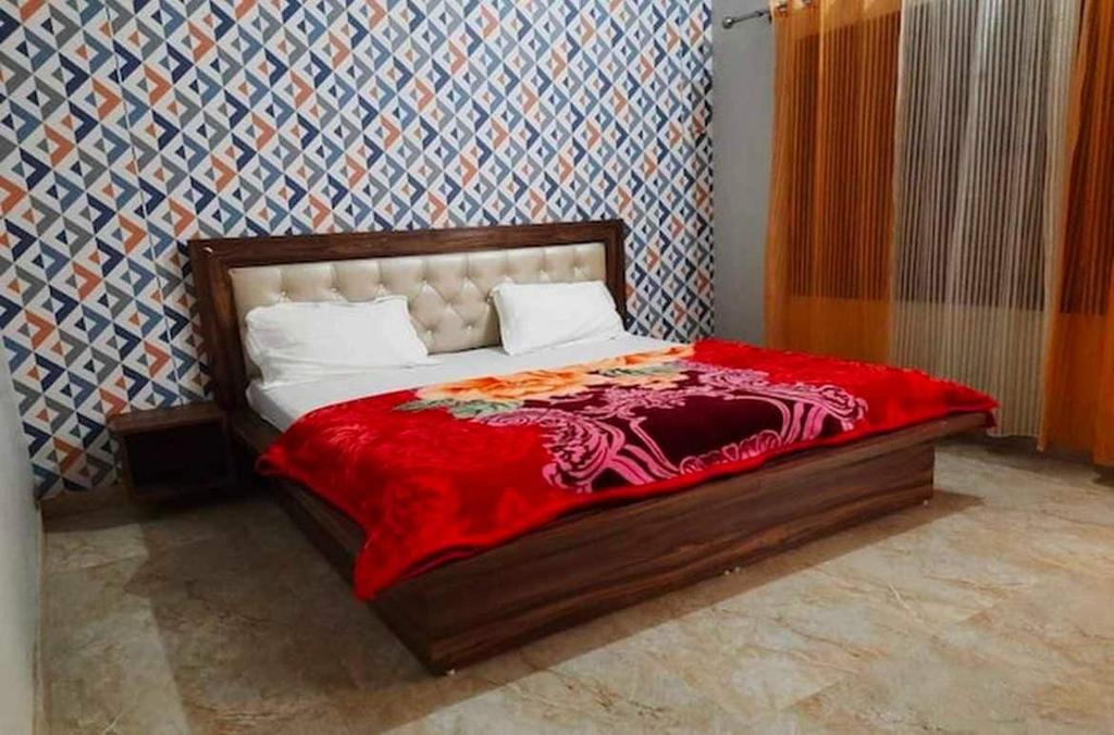 een slaapkamer met een bed met een rode deken erop bij Hotel O Ocean's 11 in Daurāla