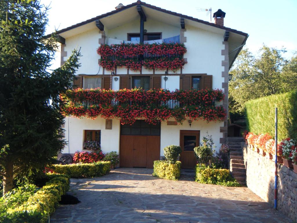 una casa con flores a un lado. en Apartamento Rural Oizalde, en Elizondo