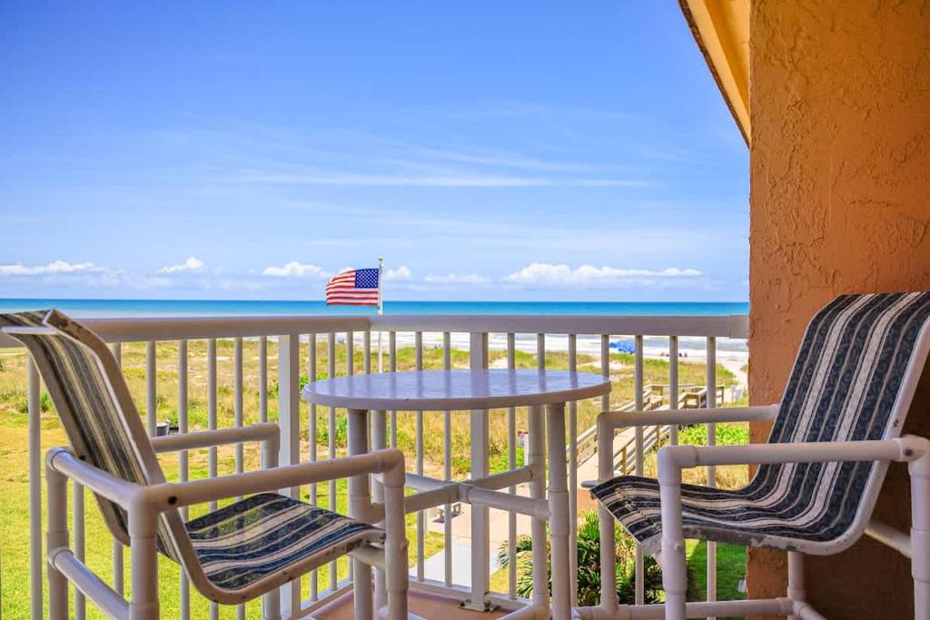 2 stoelen en een tafel op een balkon met uitzicht op de oceaan bij Endless Blue Skies - 2 Bed 2 Bath in Cocoa Beach