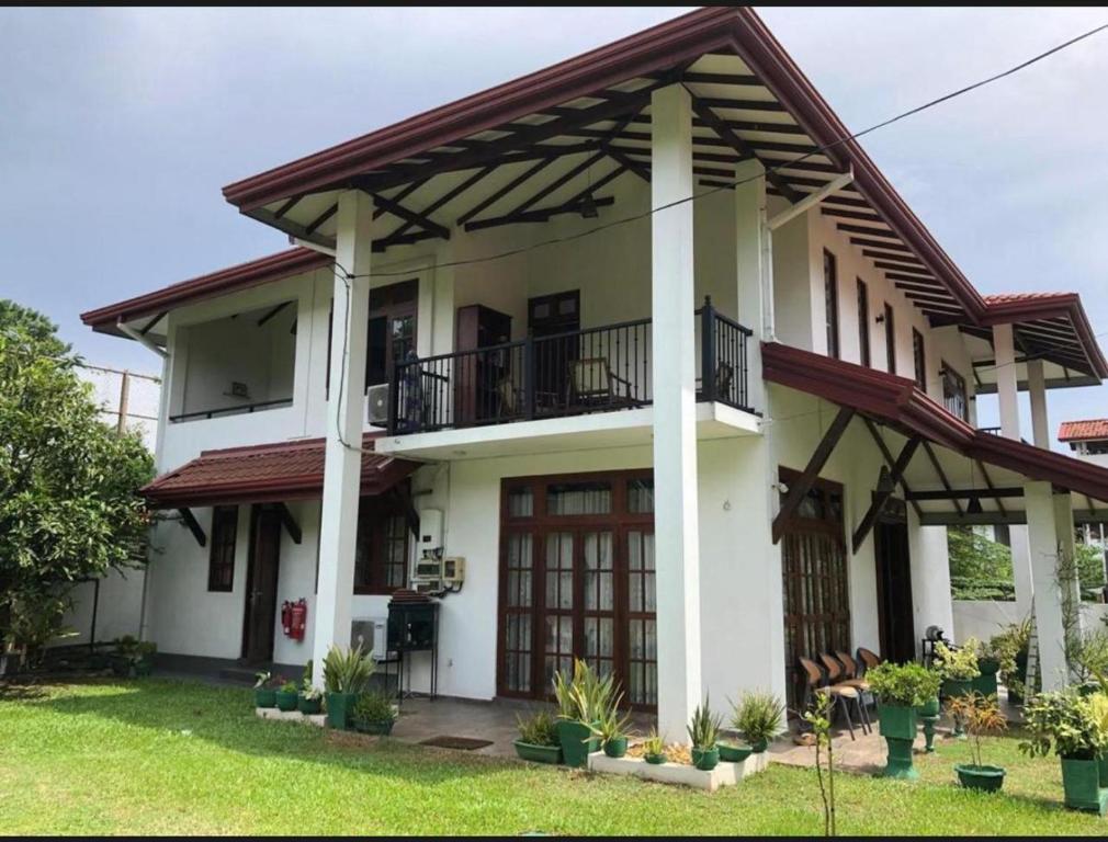 NikawatawanaにあるAirways Hotelのバルコニー付きの広い白い家