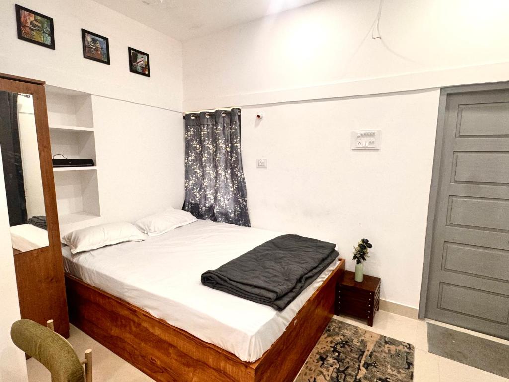 a bedroom with a bed and a window and a door at Vibes stay in 5 in Hyderabad